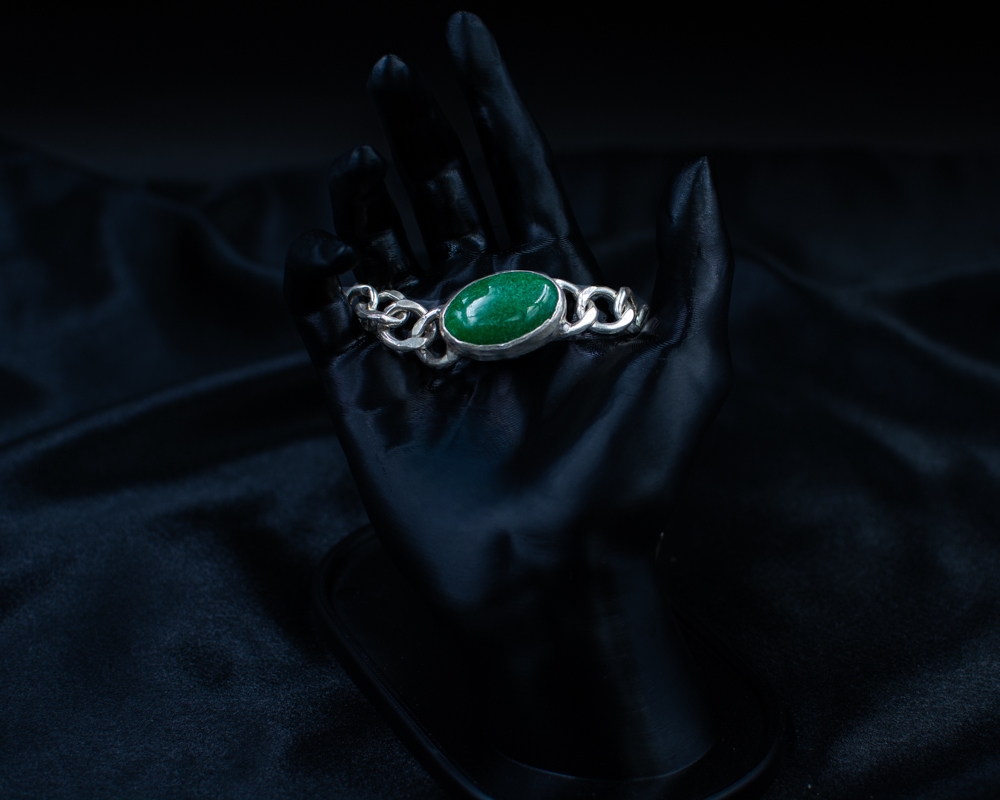 Green Bracelet shown from above on black satin and hand display
